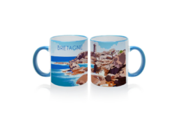 Mug anse bleue produit personnalisé Bretagne avec illustration de la côte granit rose, idéal pour souvenirs et boutiques touristiques.