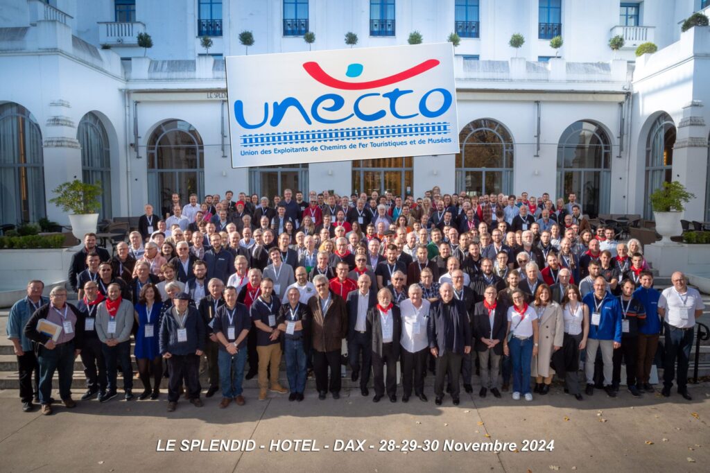 Photo de groupe avec participants du congrès UNECTO 2024 devant l’Hôtel Le Splendid, trains touristiques