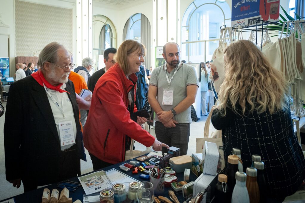 Stand HAN présentant objets souvenirs et échangeant avec acteurs de trains touristiques lors du congrès UNECTO 2024